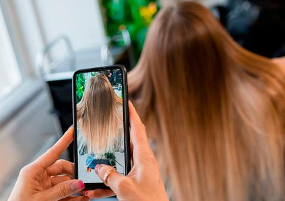 Peluquera sacando una foto del pelo de una clienta